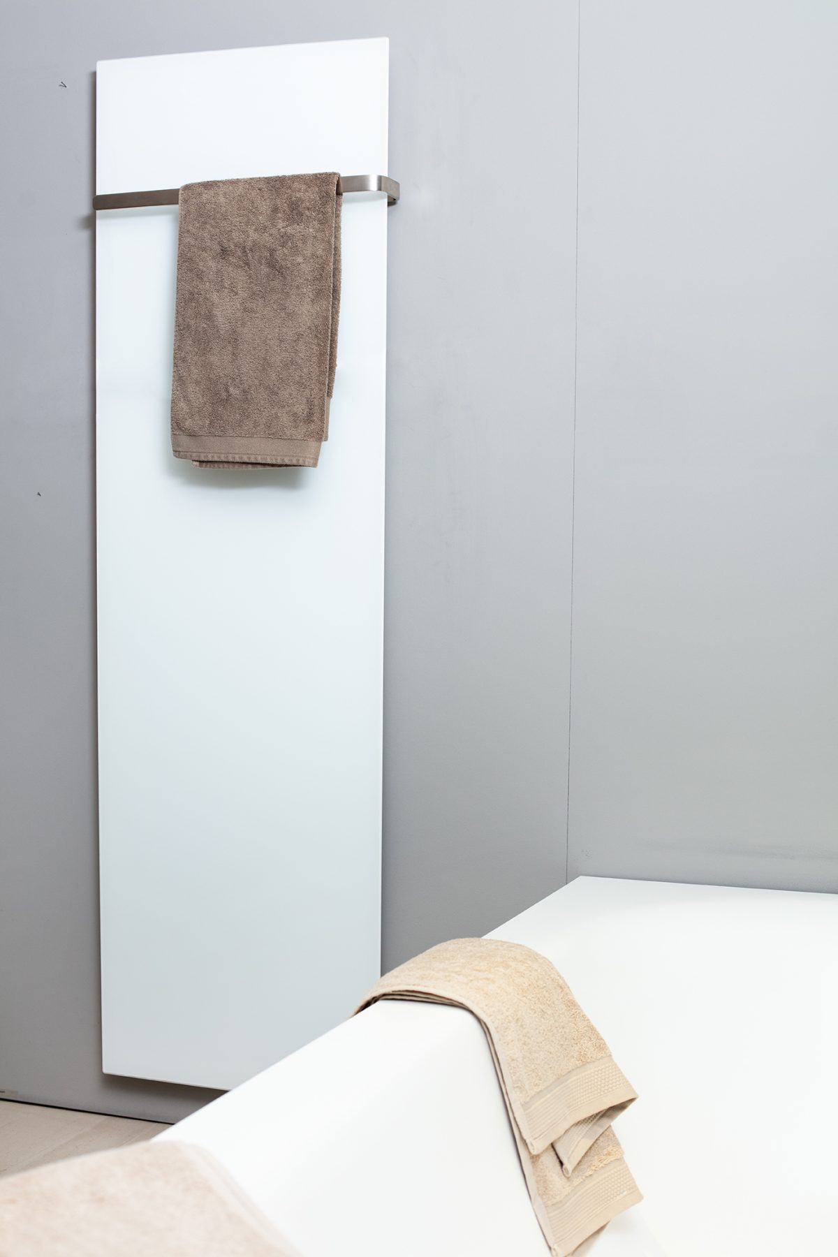 ELEMENTO vertical in Weiss matt mit braunem Handtuch neben der Badewanne